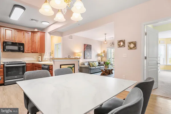a large kitchen with sink a refrigerator and chairs