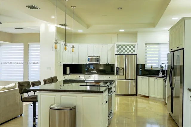 a kitchen with stainless steel appliances a refrigerator sink and microwave