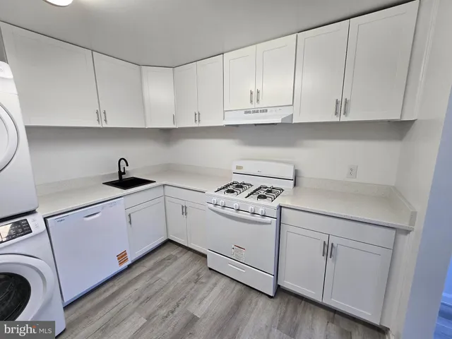 a kitchen with white cabinets and white appliances