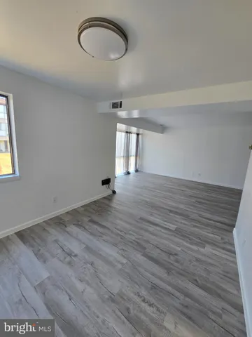 a view of a room with wooden floor and a window