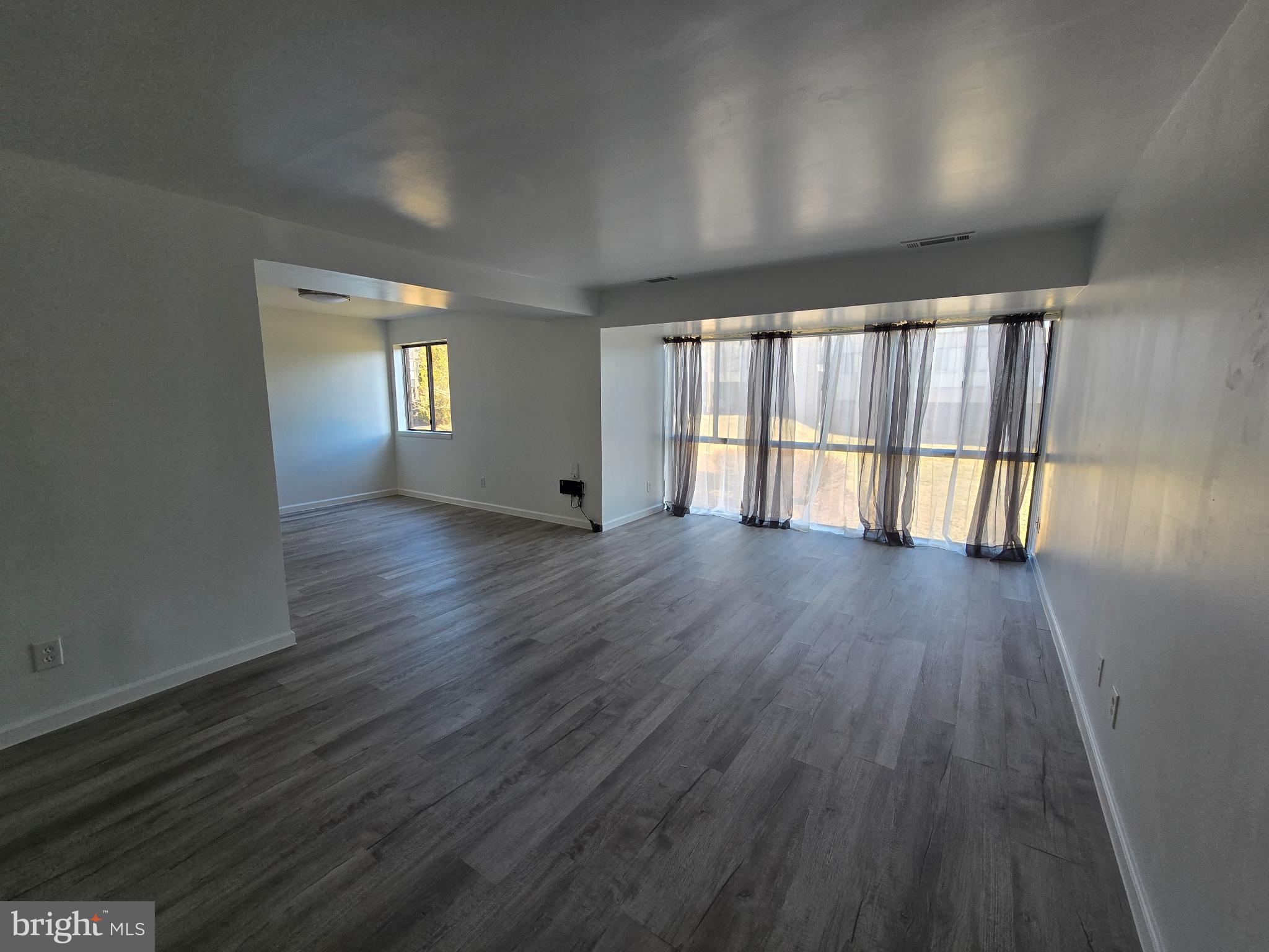 18901 Smoothstone Way, Unit I3 Gaithersburg, MD 20886 - Photo 20 of 36 an empty room with wooden floor and windows