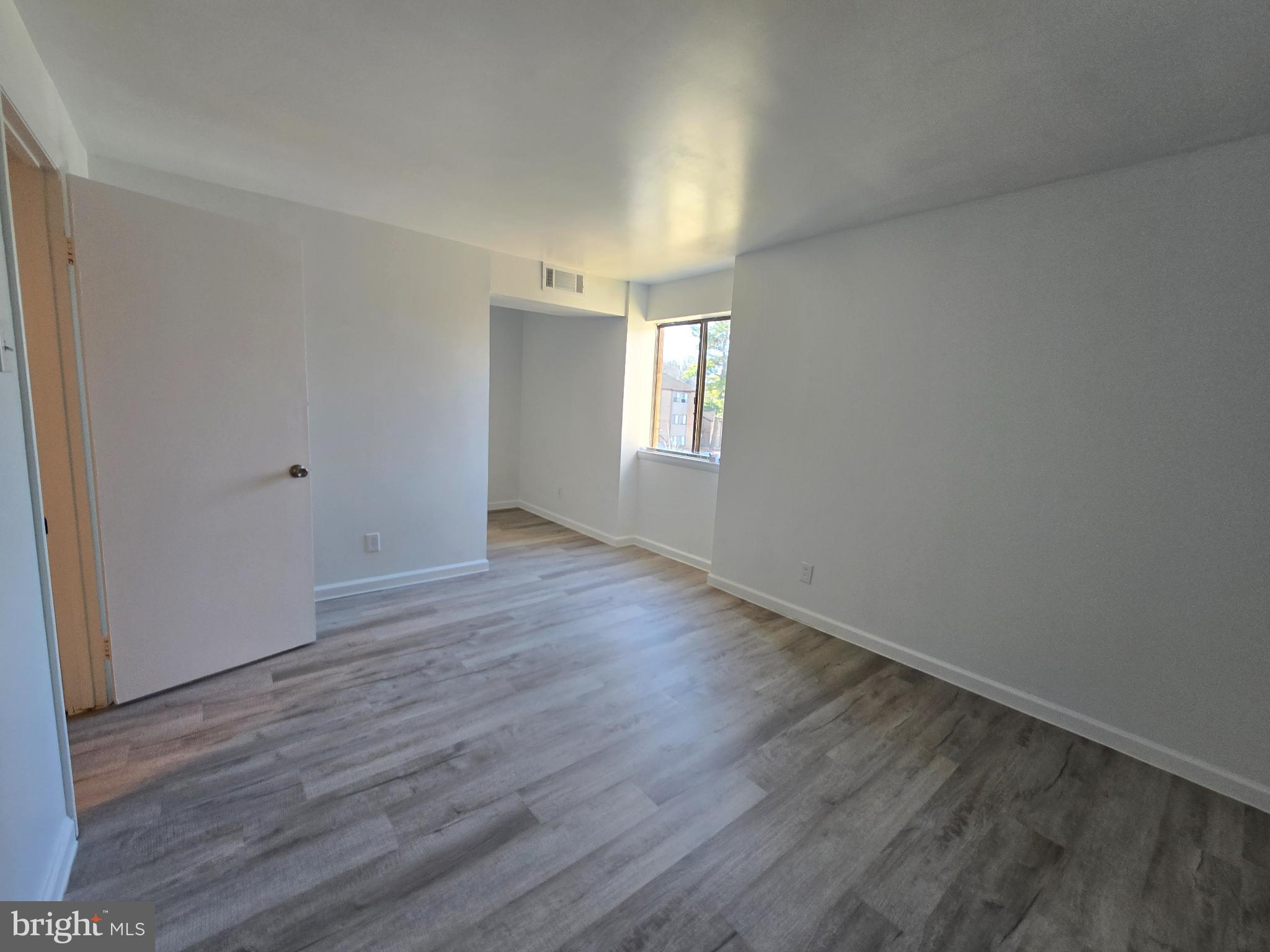 18901 Smoothstone Way, Unit I3 Gaithersburg, MD 20886 - Photo 33 of 36 a view of an empty room with wooden floor and window