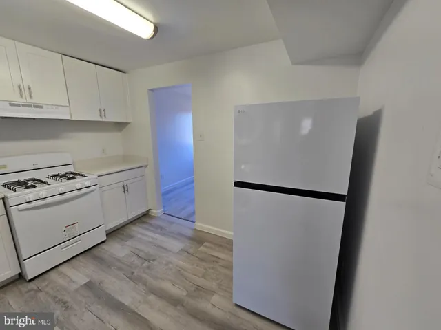 a kitchen with a refrigerator sink stove and cabinets