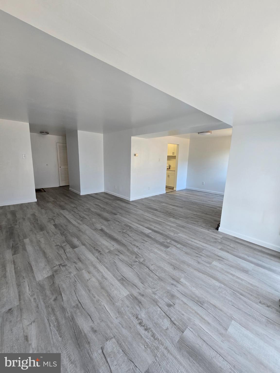 18901 Smoothstone Way, Unit I3 Gaithersburg, MD 20886 - Photo 10 of 36 a view of an empty room with wooden floor and a window