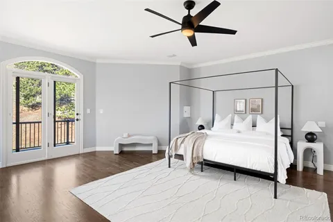 a bedroom with a large bed and a chandelier fan
