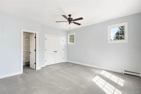 an empty room with windows and fan