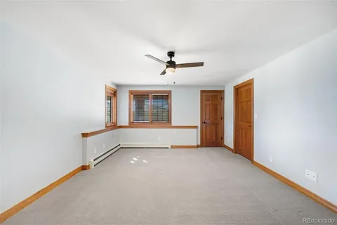an empty room with a ceiling fan and a window