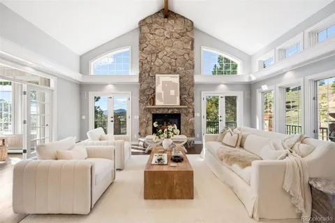 a living room with furniture fireplace and large windows