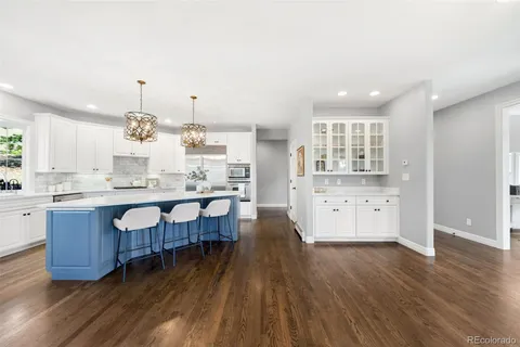 a large kitchen with lots of counter space and wooden floor