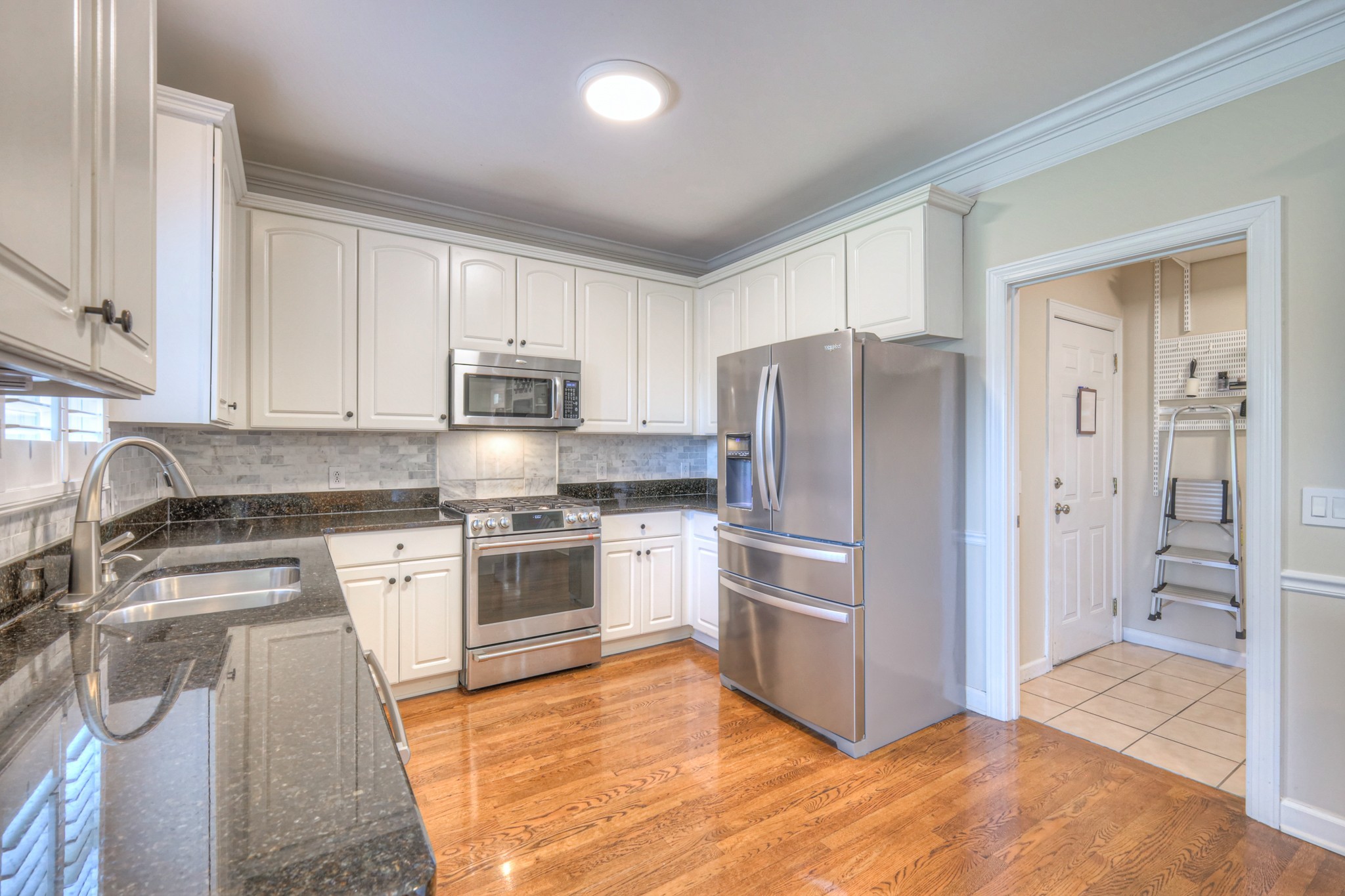 305 Eiderdown Court Franklin, TN 37064 - Photo 7 of 31 a kitchen with granite countertop a refrigerator and a stove top oven