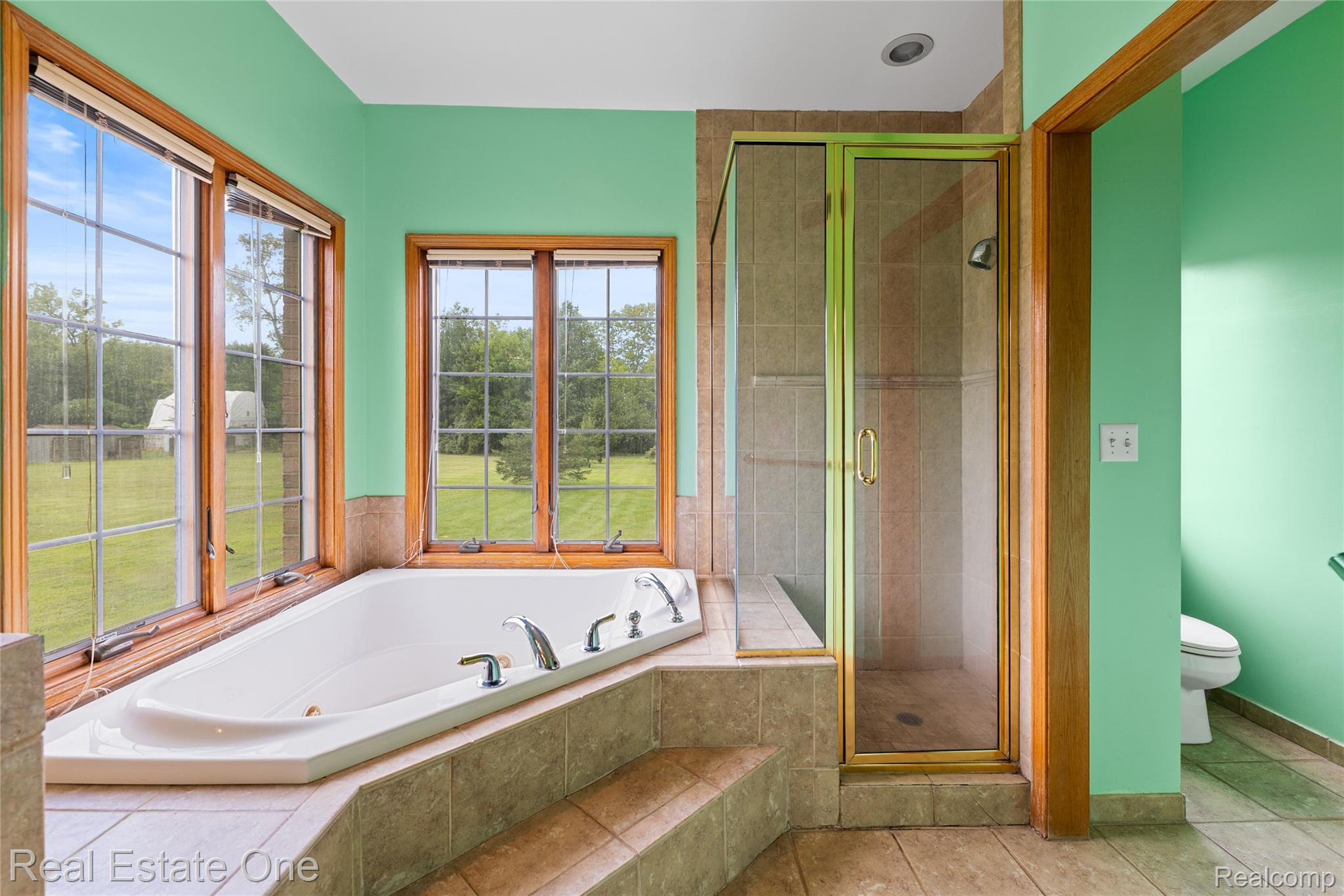 17268 Beech Daly Road Romulus, MI 48174 - Photo 36 of 60 Soaking tub with multiple jets, surrounded by tiled steps and a tiled deck