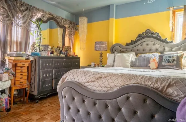 a spacious bedroom with a bed a window and dresser