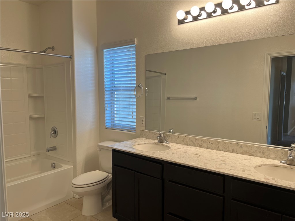 1070 Bobby Basin Avenue Henderson, NV 89014 - Photo 20 of 23 Bathroom with light tile patterned floors, double vanity, and bathtub / shower combination