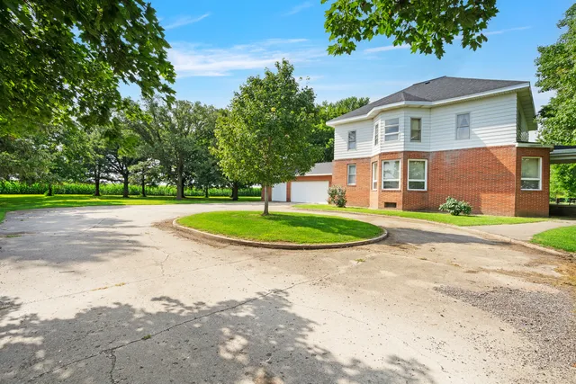 a view of a house with a yard and large trees