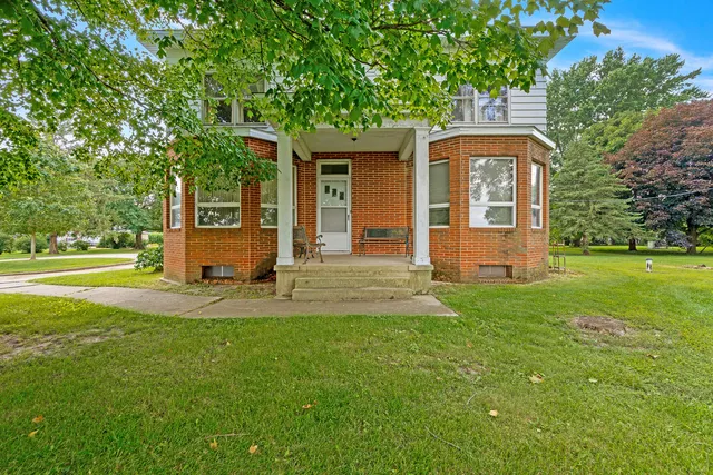 a front view of a house with yard and green space