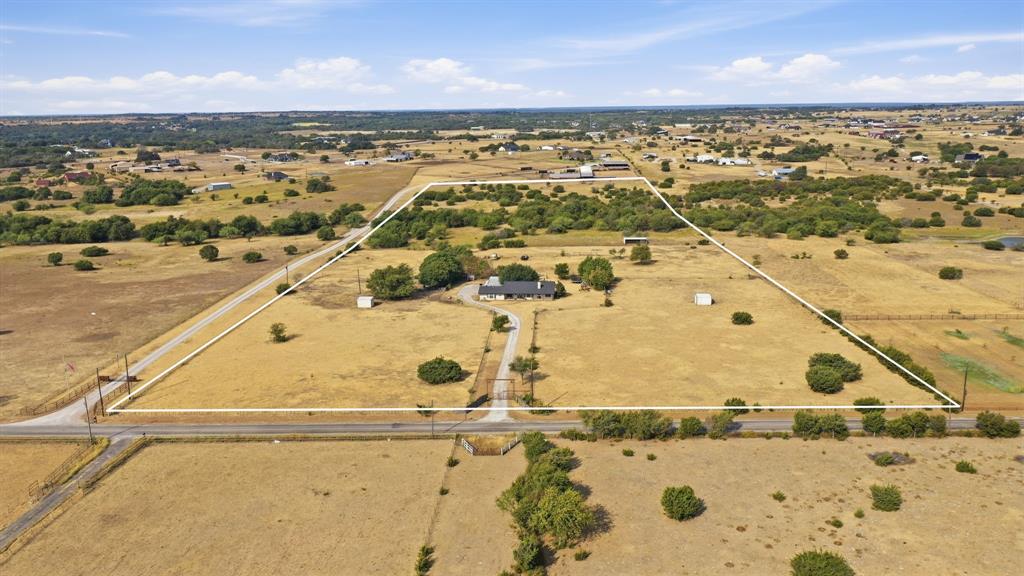 950 Johnson Bend Road Weatherford, TX 76088 - Photo 40 of 40 Expansive land parcel with a single-story residence, established driveway, and scattered natural foliage
