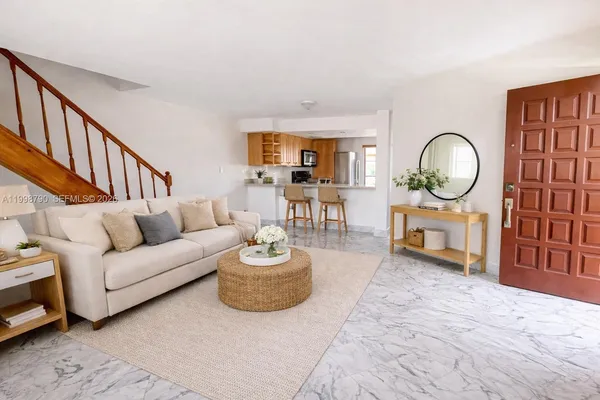 a living room with furniture a mirror and a dining table