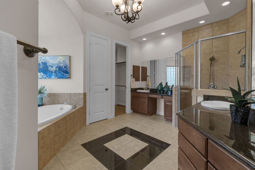 7306 Starflower Katy, TX 77494 - Photo 28 of 50 a spacious bathroom with a double vanity sink a large mirror a bathtub and a shower