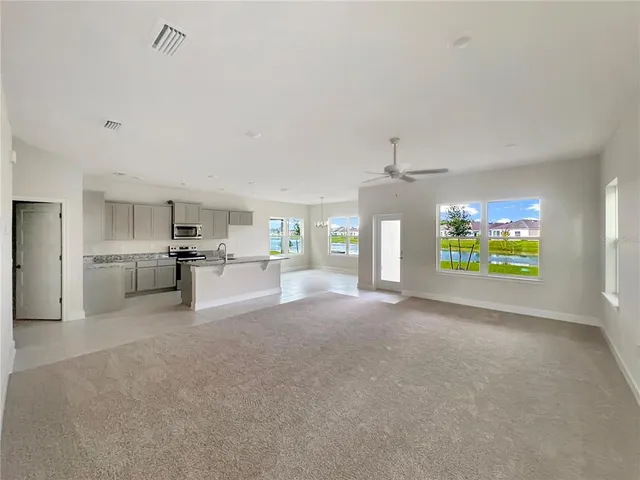 a view of a kitchen with refrigerator and windows