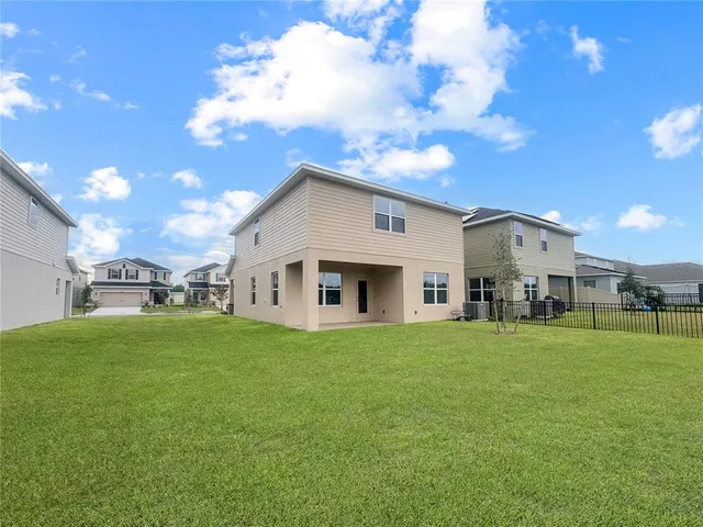 a big white house with a big yard and large trees