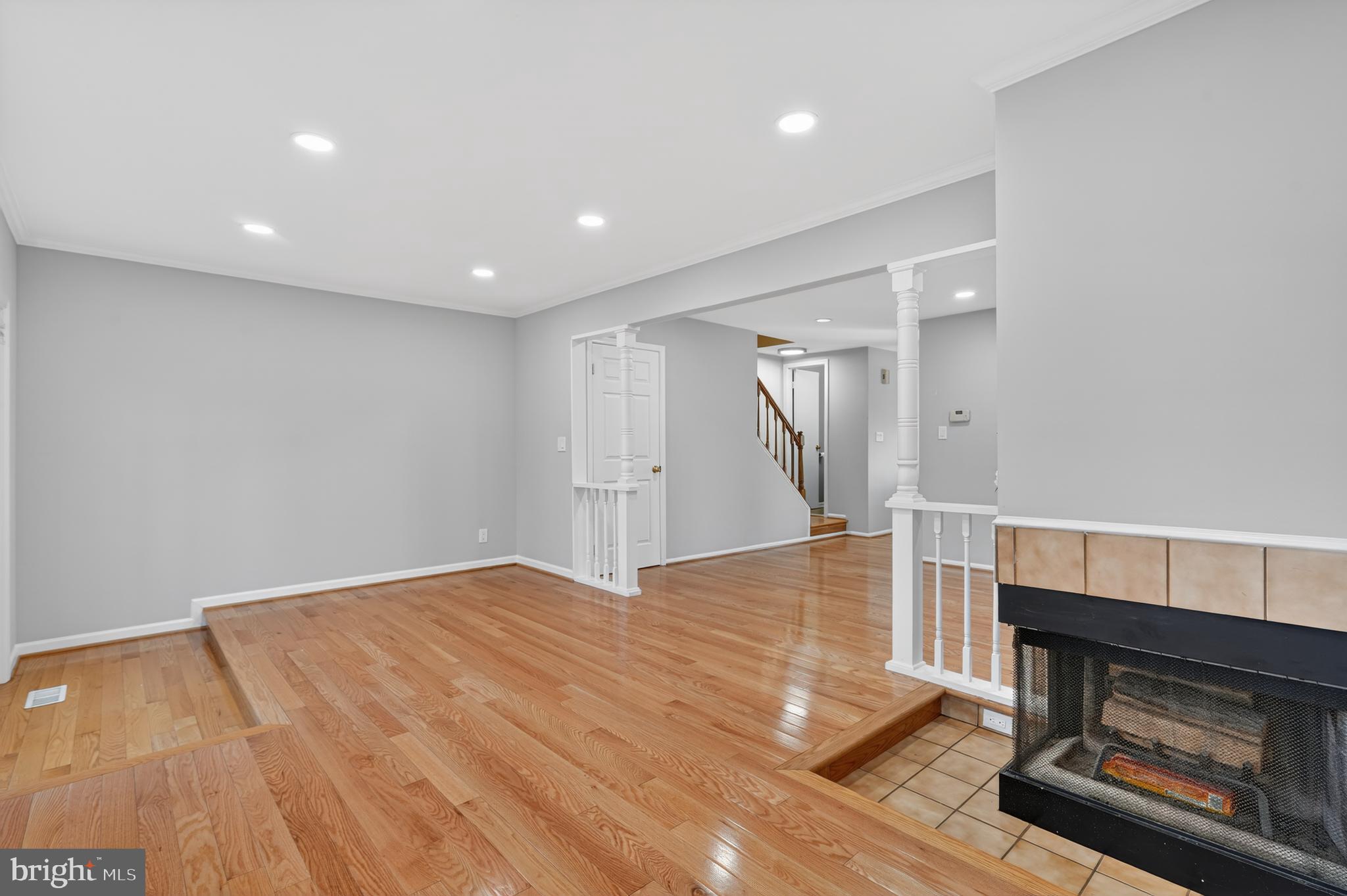 8868 Winding Hollow Way Springfield, VA 22152 - Photo 21 of 53 a view of empty room with wooden floor and fireplace