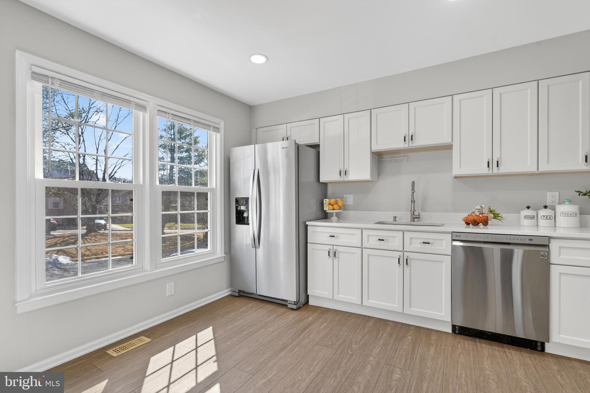 8868 Winding Hollow Way Springfield, VA 22152 - Photo 7 of 53 a kitchen with stainless steel appliances granite countertop a stove a sink dishwasher a refrigerator and cabinets with wooden floor