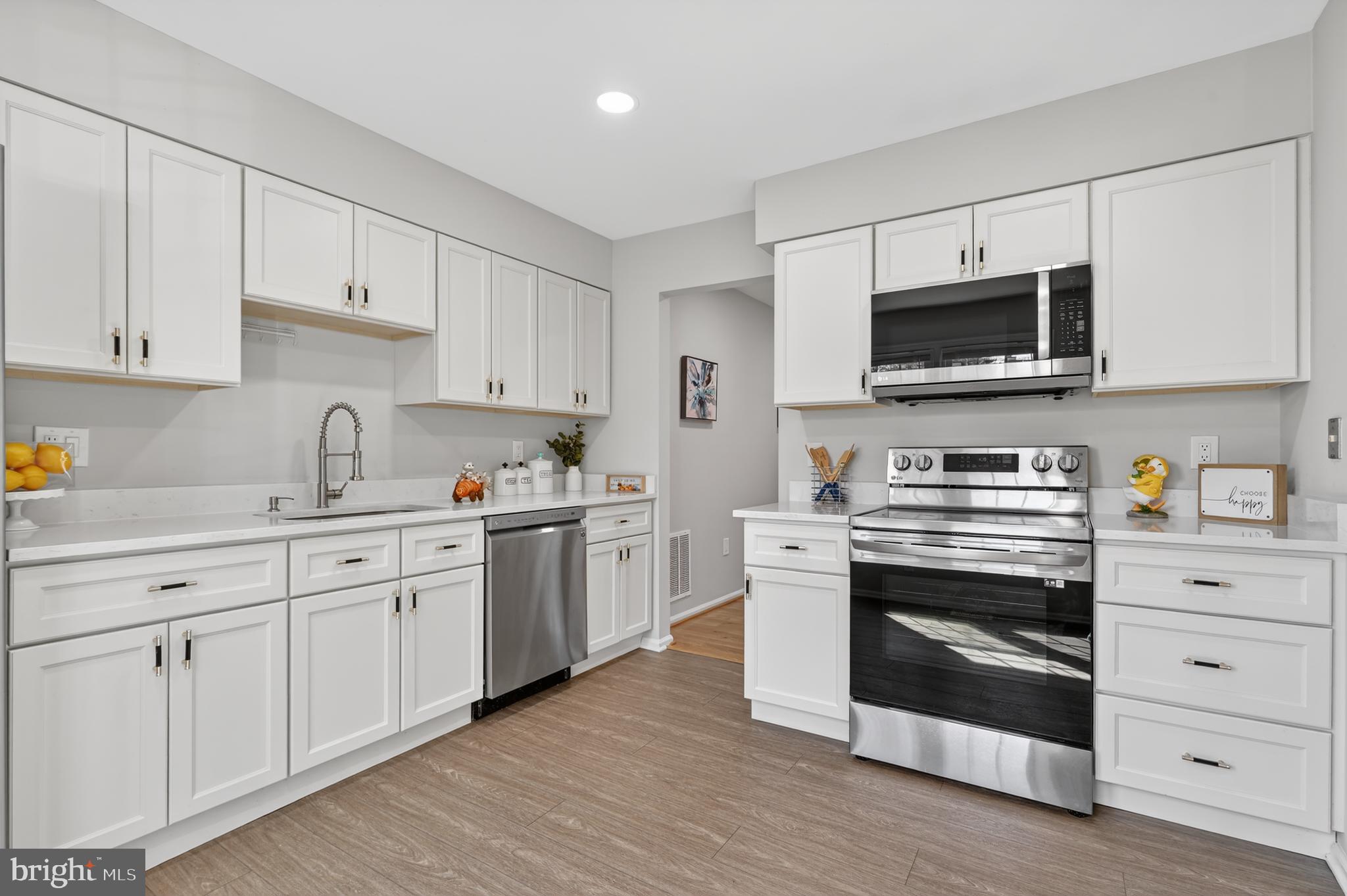 8868 Winding Hollow Way Springfield, VA 22152 - Photo 8 of 53 a kitchen with white cabinets and stainless steel appliances