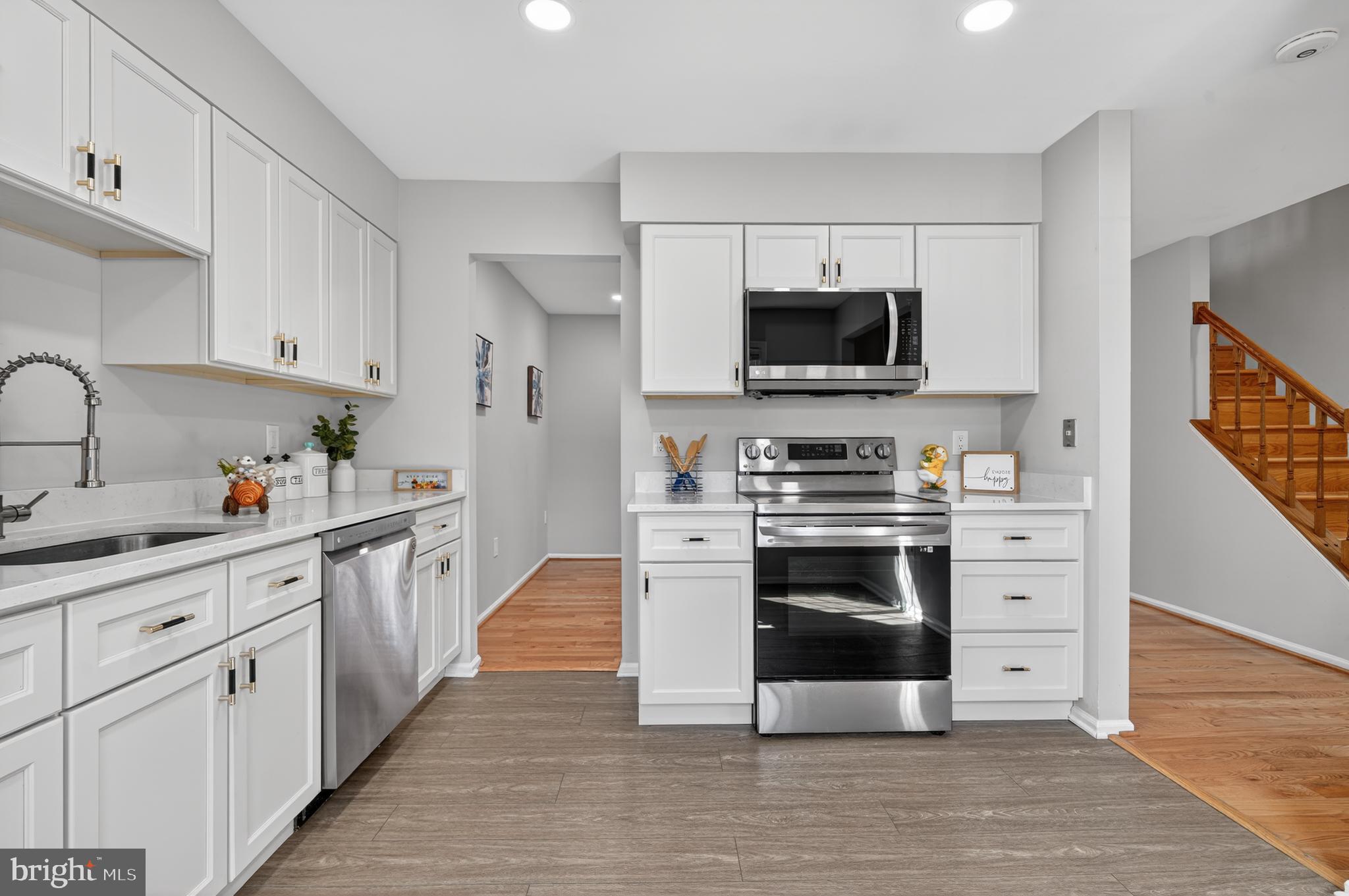8868 Winding Hollow Way Springfield, VA 22152 - Photo 9 of 53 a kitchen with white cabinets and stainless steel appliances