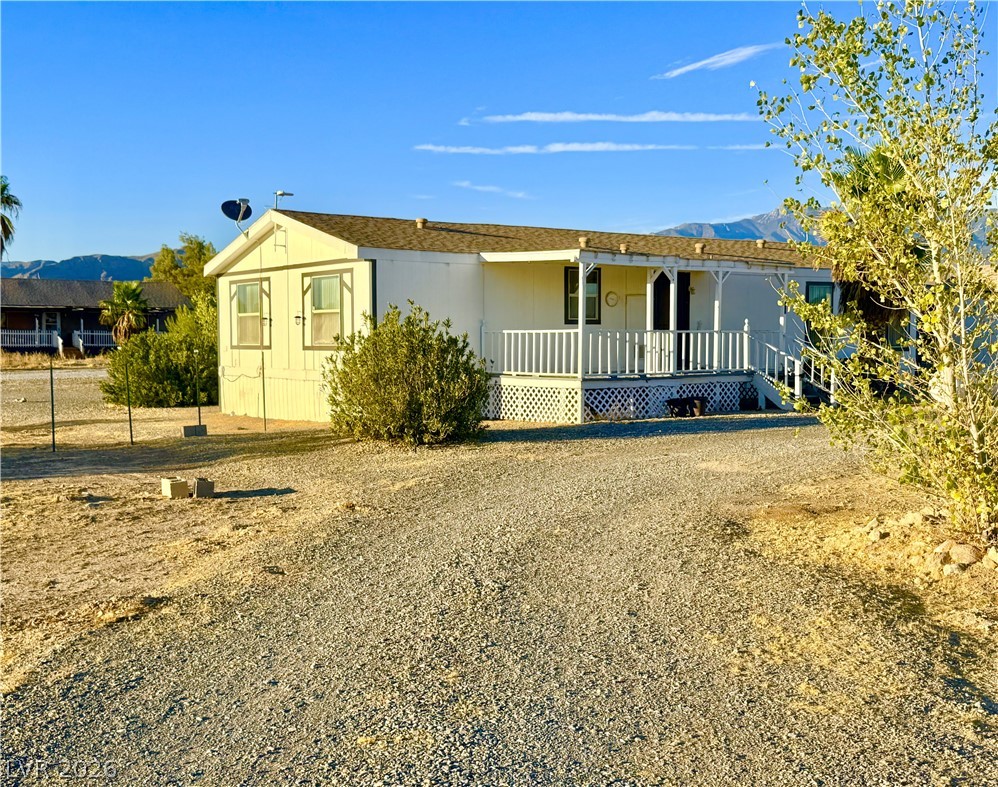 6471 Hafen Ranch Road Pahrump, NV 89061 - Photo 1 of 22 A welcoming front porch enhances this home's curb appeal, set against a desert landscape with mountain views.