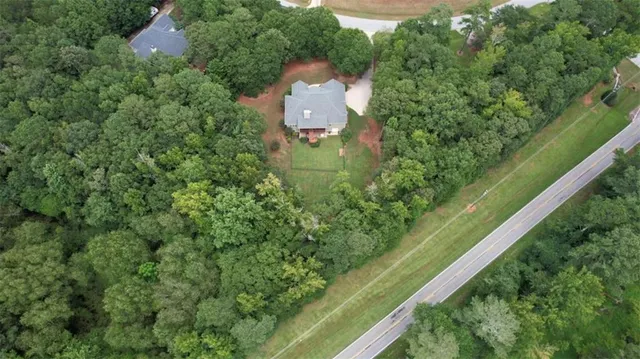 a kitchen with stainless steel appliances granite countertop a refrigerator a sink dishwasher a dining table and chairs with wooden floor