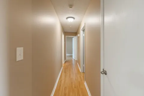a view of a hallway with wooden floor