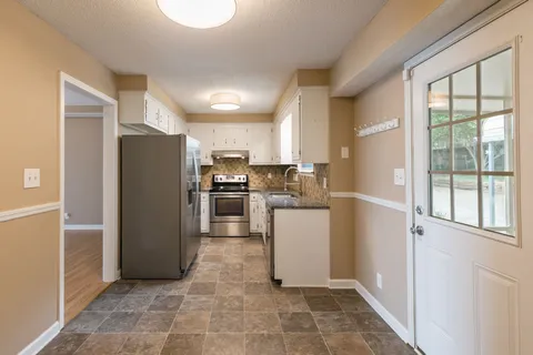 a kitchen with a refrigerator sink stove and cabinets