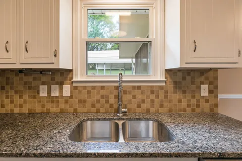 a kitchen with granite countertop a sink and granite counter tops