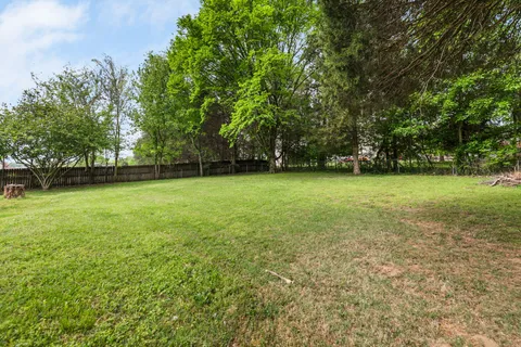 a view of a green field with trees in the background