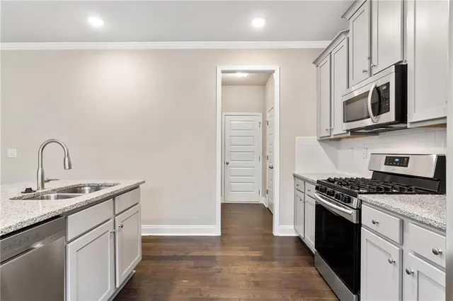 a kitchen with stainless steel appliances granite countertop a sink and a stove
