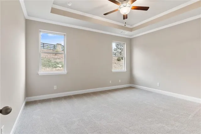 an empty room with windows and ceiling fan