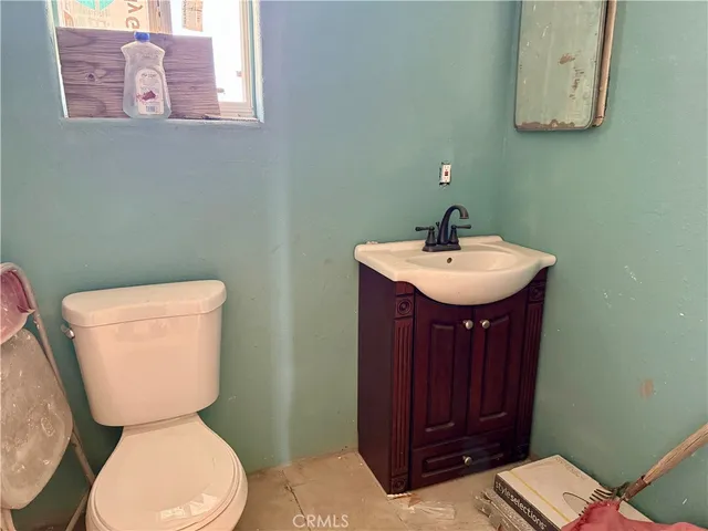 a bathroom with a toilet a sink and mirror