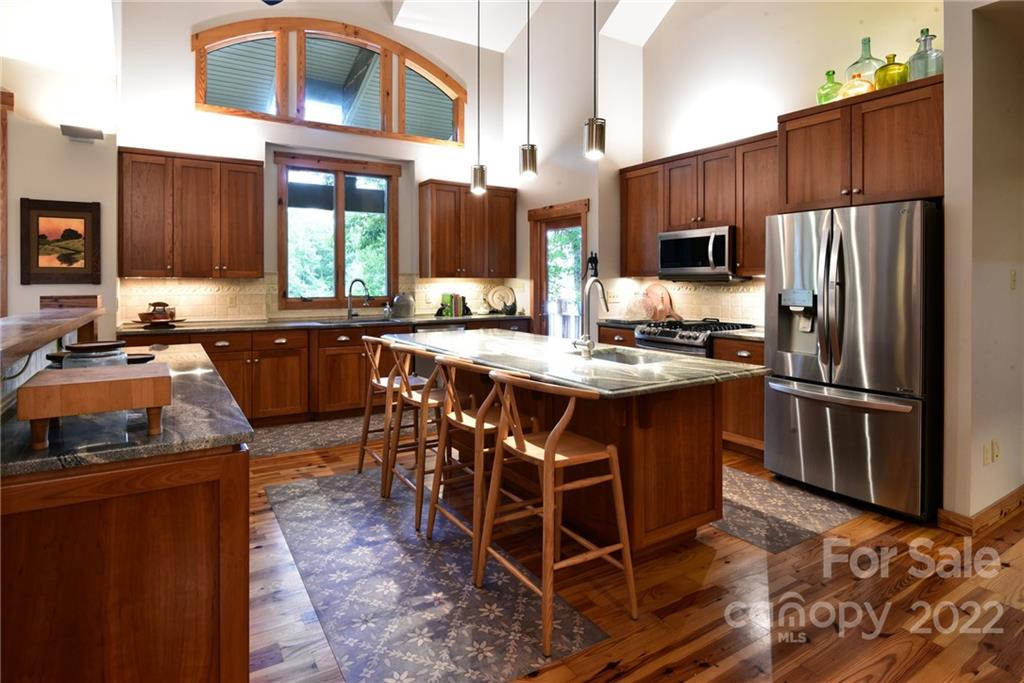 175 Clearview Point Drive Mount Gilead, NC 27306 - Photo 17 of 48 a kitchen with stainless steel appliances a sink a stove a refrigerator cabinets and a dining table