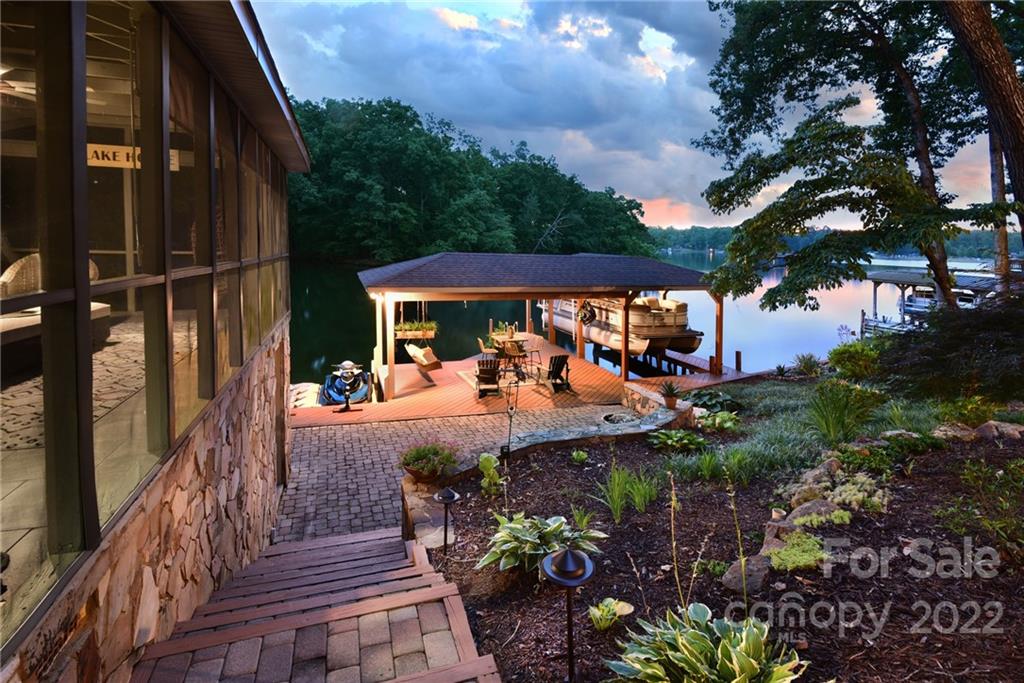 175 Clearview Point Drive Mount Gilead, NC 27306 - Photo 43 of 48 a view of a patio with table and chairs potted plants with wooden floor and fence