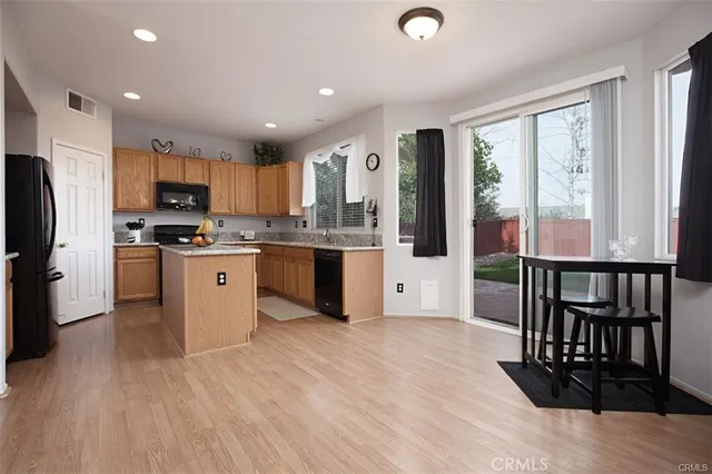 a kitchen with stainless steel appliances granite countertop a refrigerator a stove top oven a sink dishwasher and wooden cabinets