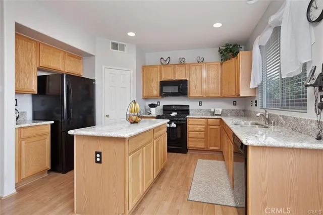 a kitchen with stainless steel appliances granite countertop a sink stove refrigerator and a window