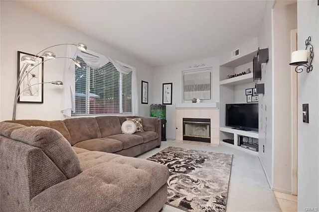 a living room with furniture a flat screen tv and a fireplace
