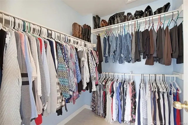 a view of walk in closet with clothes