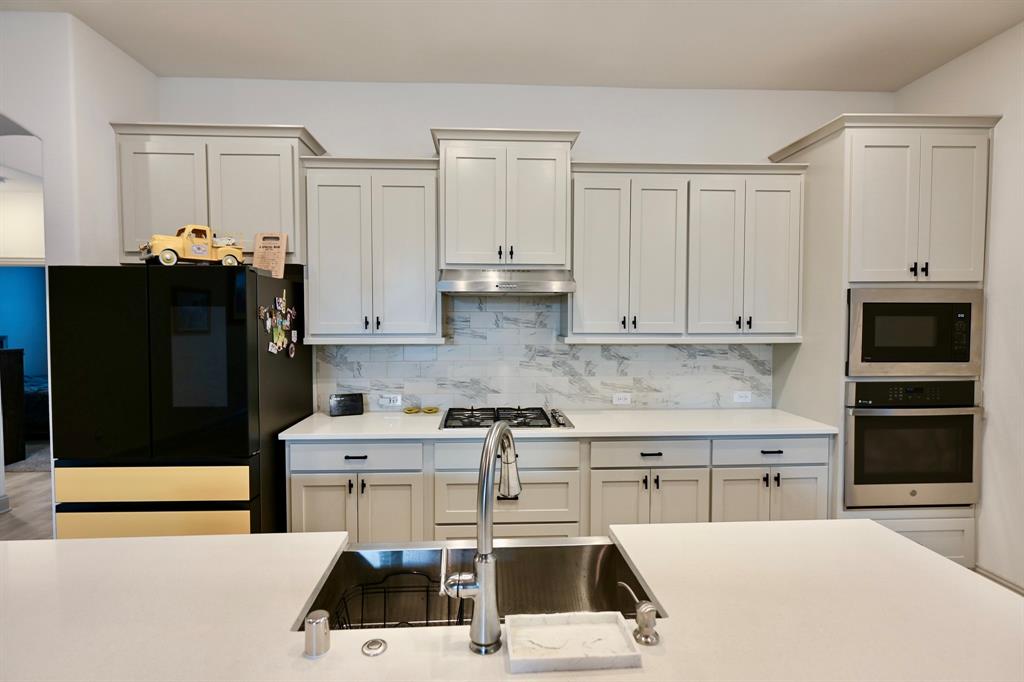 2609 Henley Way Venus, TX 76084 - Photo 18 of 40 a kitchen with a sink a stove and refrigerator