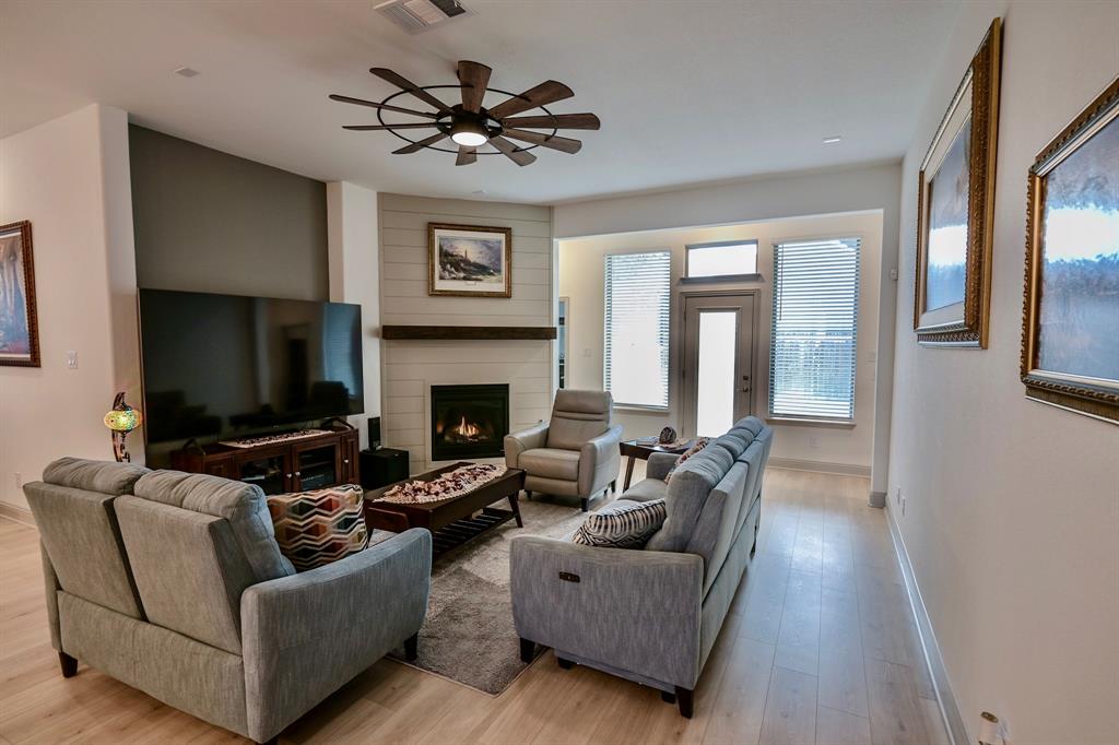 2609 Henley Way Venus, TX 76084 - Photo 21 of 40 a living room with furniture a flat screen tv and a fireplace