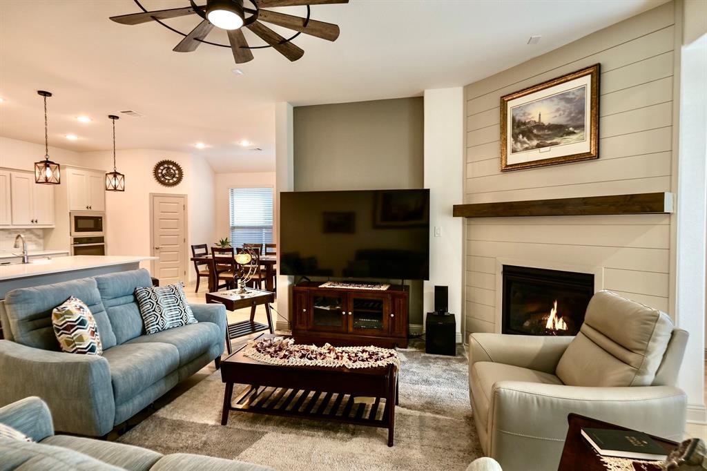 2609 Henley Way Venus, TX 76084 - Photo 22 of 40 a living room with furniture a flat screen tv and a fireplace