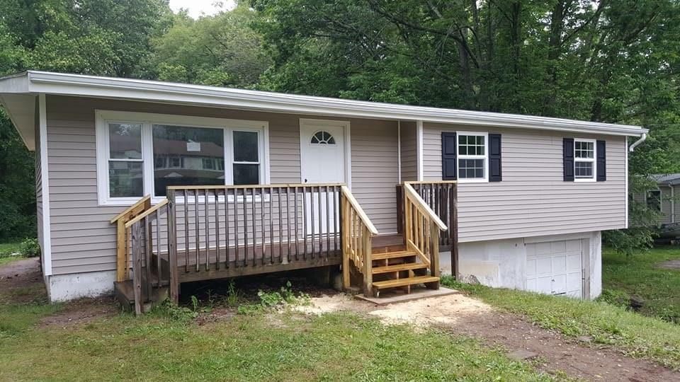 a view of a house with a yard and deck