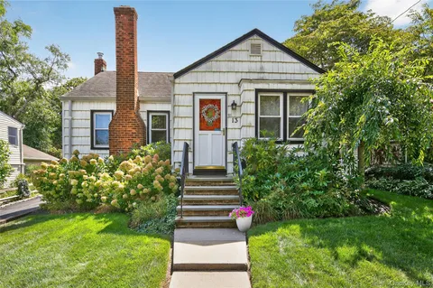 a front view of a house with a yard and trees
