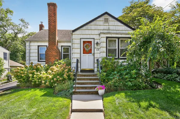a front view of a house with a yard and trees