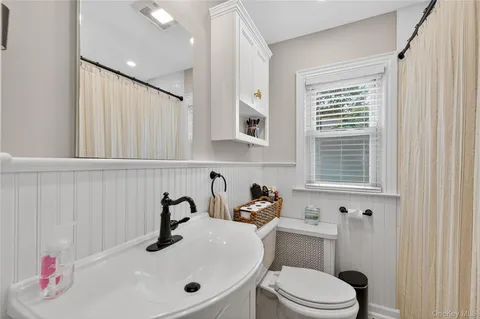 a bathroom with a sink vanity mirror and toilet